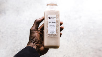a man holding a bottle with sea moss written on it